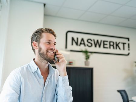 Medewerker van NasWerkt aan het bellen met een kandidaat: op zoek naar de juiste medewerker